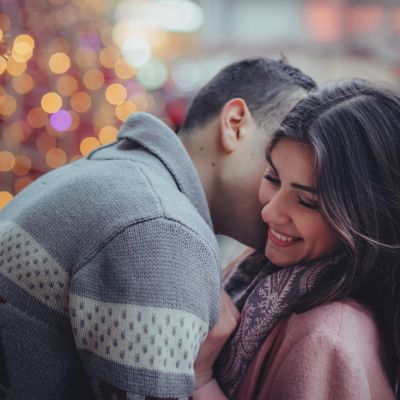 Young couple embracing infront of a Christmas tree downtown Toronto