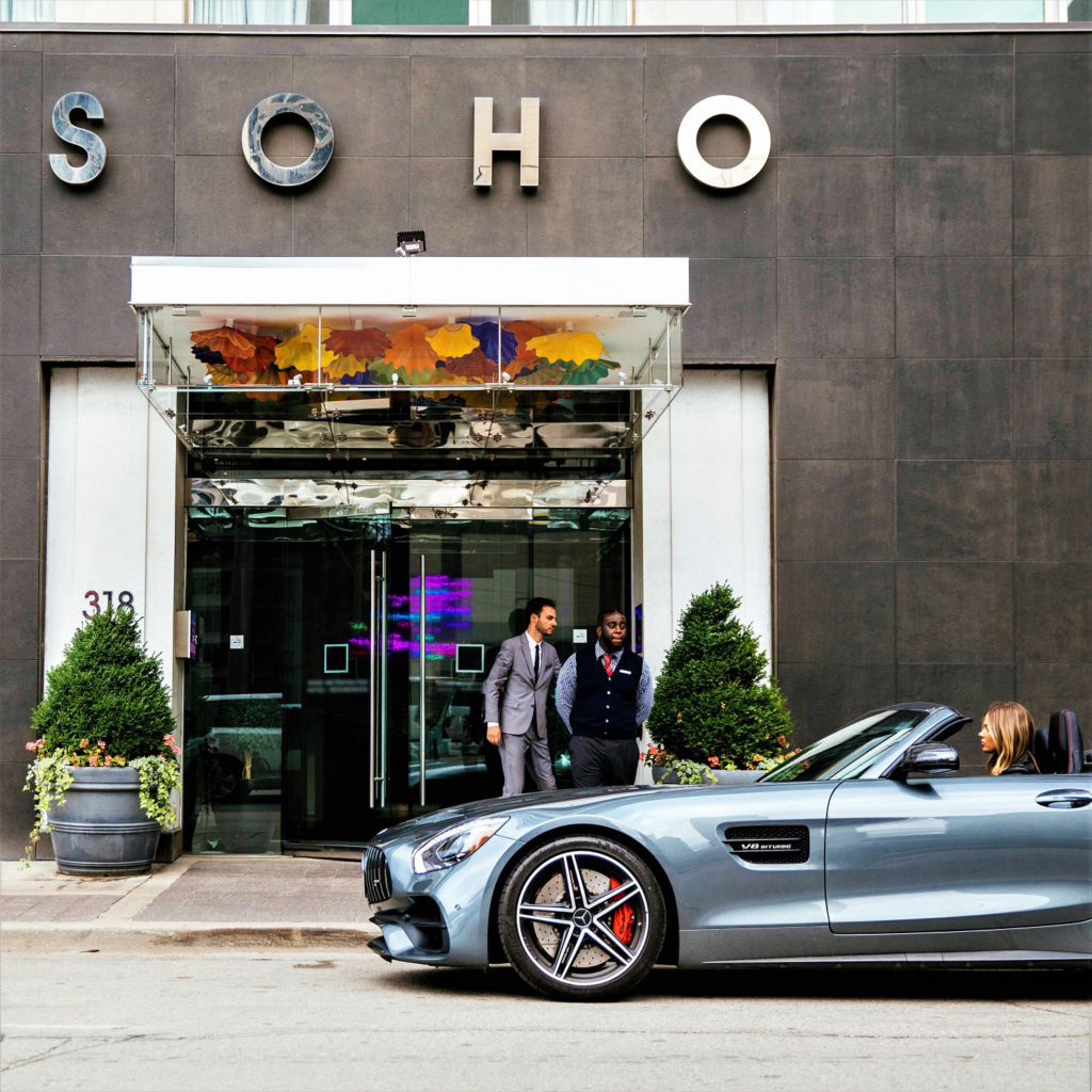 Female model in a sports car pulls up to The SoHo Hotel's valet service